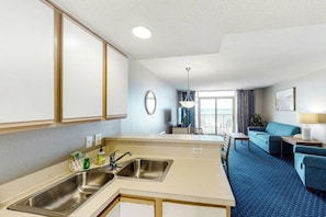 A compact hotel room with a kitchenette, a dining area, and a seating space. - Bay Watch Resort 0314 (North Myrtle Beach)