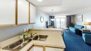 Ein Hotelzimmer mit Küchenzeile, einem Essbereich und einem Wohnbereich.