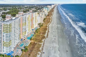 A coastal hotel with multiple high-rise buildings, a beachfront, and a swimming pool area. - Bay Watch Resort 0314 (North Myrtle Beach)