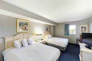 A hotel room with two beds, a television, a desk, and artwork on the walls. - Bay Watch Resort 0314 (North Myrtle Beach)