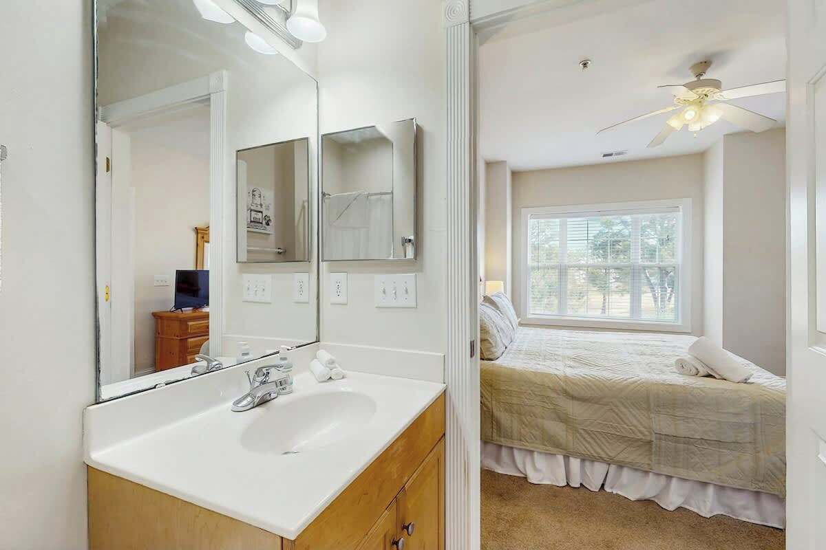 A bedroom with a bed, a window, and a ceiling fan.