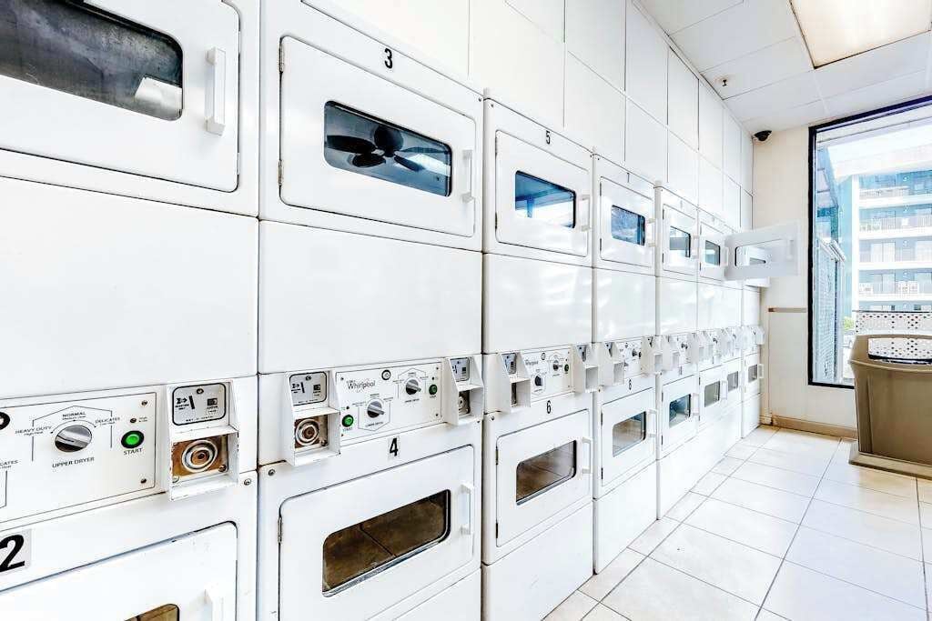 Filera de rentadores blanques amb panells de control, numerades del 2 al 6, en una habitació amb terra de rajola i una finestra que donava als edificis.