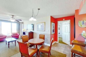 A hotel room with a dining area, a TV, and a door leading to another room. - Bahama Sands Unit 0701 (North Myrtle Beach)