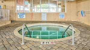 An indoor swimming pool with a 3 FT depth sign, surrounded by a brick floor, with safety signs on the walls. - Bahama Sands Unit 0701 (North Myrtle Beach)