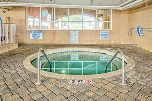 An indoor swimming pool with a 3 FT depth sign, surrounded by a brick floor, with safety signs on the walls. - Bahama Sands Unit 0701 (North Myrtle Beach)