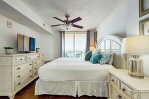 A bedroom with a bed, a ceiling fan, a dresser, a lamp, and a television. - Bahama Sands Unit 0708 (North Myrtle Beach)