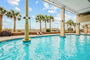 A swimming pool with lounge chairs and palm trees. - Bahama Sands Unit 0806 (North Myrtle Beach)
