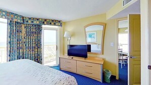 Ein Hotelzimmer mit Bett, Fernseher, Schreibtisch und Stuhl.