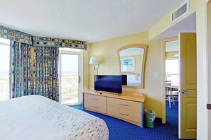 Ein Hotelzimmer mit Bett, Fernseher, Schreibtisch und Stuhl.