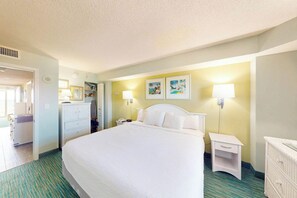 A hotel room with a large bed, bedside tables, a wardrobe, and artwork on the walls. - Bay Watch Resort 0407 (North Myrtle Beach)