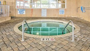 An indoor swimming pool with a 3 FT depth sign, surrounded by a brick floor, with safety signs on the walls. - Bahama Sands Unit 0905 (North Myrtle Beach)