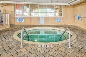 An indoor swimming pool with a 3 FT depth sign, surrounded by a brick floor, with safety signs on the walls. - Bahama Sands Unit 0905 (North Myrtle Beach)