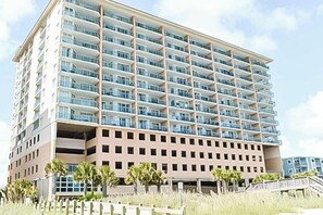 Ein mehrstöckiges Hotel mit einheitlicher Fassade, Balkonen in jeder Etage und einer flachen Dachfläche.