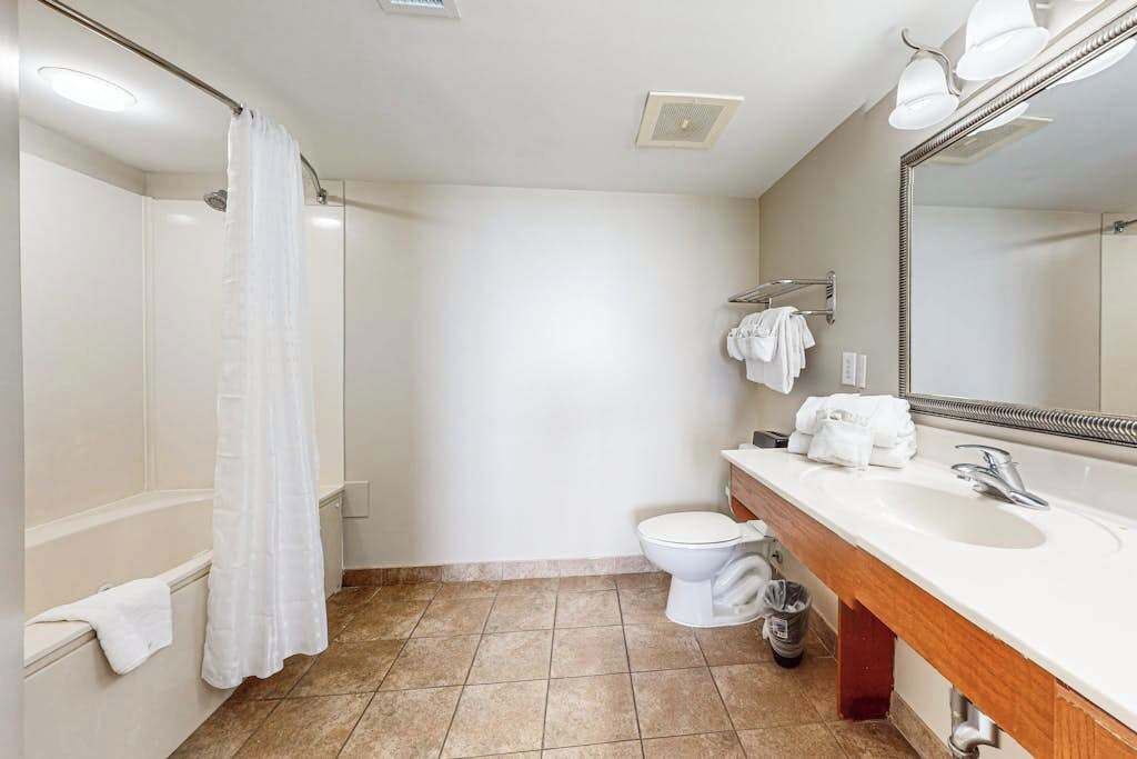 A bathroom with a shower, toilet, and sink.