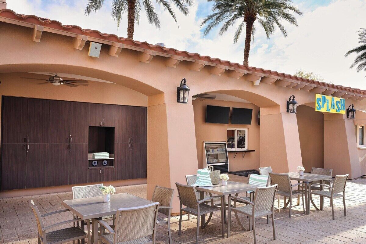 Un patio al aire libre con una mesa y sillas de comedor, una parrilla y un letrero que dice 'SPLASH'.