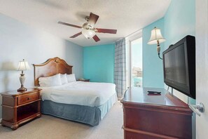 A hotel room with a bed, a nightstand, a dresser, a television, and a ceiling fan. - Bahama Sands Unit 0902 (North Myrtle Beach)