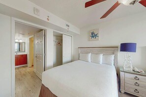Ein Schlafzimmer mit einem Bett, einem Nachttisch und einem Deckenventilator.