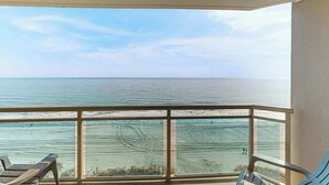 En balkong med utsikt över havet och stranden.
