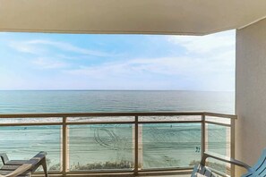 Ein Balkon mit Blick auf den Ozean und den Strand.