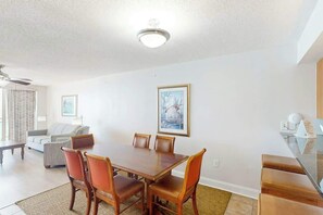 Ein Essbereich mit Holztisch und -stühlen, einer Couch und einem Bild an der Wand.