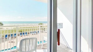 Een balkon met uitzicht op strand en zwembad.