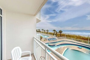 A balcony with a view of a beach and a swimming pool. - Bay Watch Resort 0234 (North Myrtle Beach)