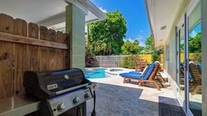 An outdoor patio with a grill, lounge chairs, and a swimming pool. - Buttonwood Corner by Avantstay Midtown Key West Private Pool + Tropical Patio Near Beaches (Key West)