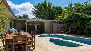 A backyard with a swimming pool, a dining table, and outdoor seating. - Buttonwood Corner by Avantstay Midtown Key West Private Pool + Tropical Patio Near Beaches (Key West)