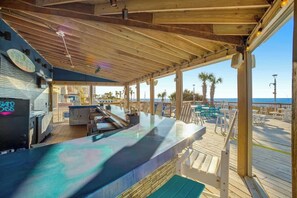 Eine Außenterrasse mit Holzdeck, Sitzgelegenheiten und Blick auf den Ozean.