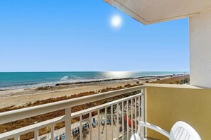 Ein Balkon mit Blick auf Strand und Meer.