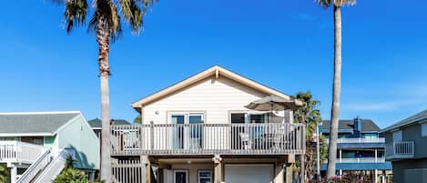 A two-story house with a balcony, a garage, and a driveway.