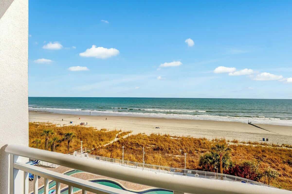 A balcony with a view of a beach and ocean.