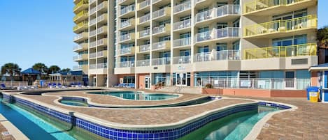 Un hotel a più piani con area piscina, caratterizzata da una forma sinuosa e indicatore di profondità a circa 90 centimetri.