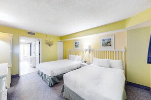 A hotel room with two beds, a bathroom, and a hallway leading to other rooms. - Bay Watch Resort 0604 (North Myrtle Beach)