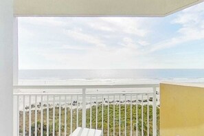 Ein Balkon mit Blick auf Strand und Meer.