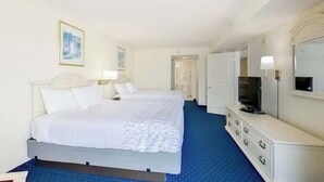 Ein Hotelzimmer mit Bett, Nachttischlampen, Fernseher, Kommode und Spiegel.