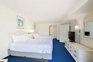 A hotel room with a bed, bedside lamps, a television, a dresser, and a mirror. - Bay Watch Resort 0621 (North Myrtle Beach)
