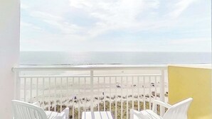 Ein Balkon mit Blick auf den Strand und den Ozean.