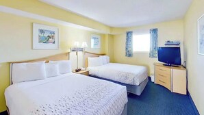A hotel room with two beds, a television, a desk with drawers, and two framed pictures on the wall. - Bay Watch Resort 0807 (North Myrtle Beach)