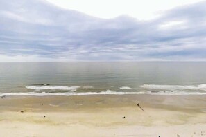 A beach with a wide sandy shore and calm water. - Bay Watch Resort 0810 (North Myrtle Beach)