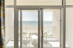 A balcony with a view of the sea, white chairs, and a table. - Bay Watch Resort 0814 (North Myrtle Beach)