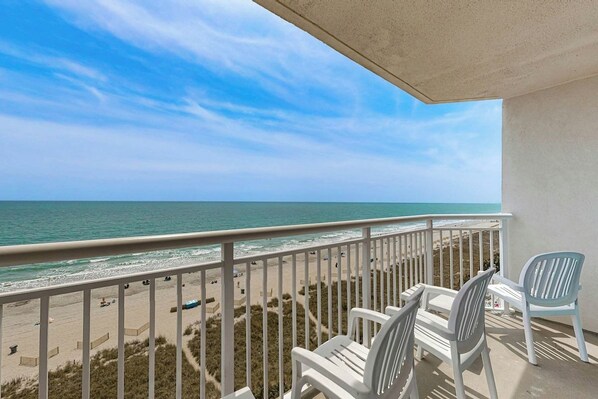 Ein Balkon mit Blick auf Strand und Meer.
