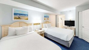 Ein Hotelzimmer mit zwei Betten, einem Fernseher und Bildern an den Wänden.
