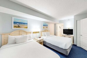 A hotel room with two beds, a television, and artwork on the walls. - Bay Watch Resort 0917 (North Myrtle Beach)