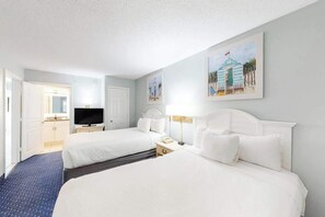 A hotel room with two beds, a television, and artwork on the walls. - Bay Watch Resort 0917 (North Myrtle Beach)