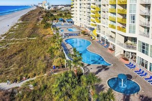 Ein Resort mit Swimmingpool, Liegestühlen und Blick auf den Strand.