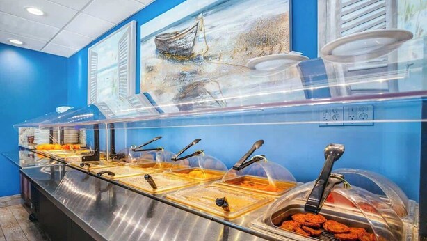 Montaje tipo buffet con múltiples estaciones de servicio, cada una cubierta por una cúpula transparente y equipada con utensilios.