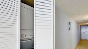 Ein Flur mit einem Waschraum, der einen Trockner und ein an der Wand montiertes Bedienfeld zeigt.
