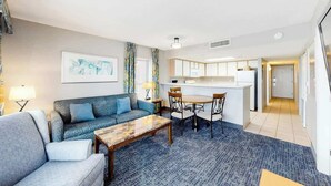 Ein modernes Wohnzimmer mit Sofa, Couchtisch und Essbereich.