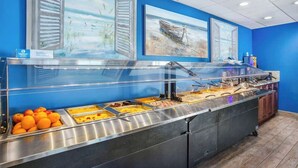 A buffet area with various food options and artwork on the walls. - Bay Watch Resort 1233 (North Myrtle Beach)